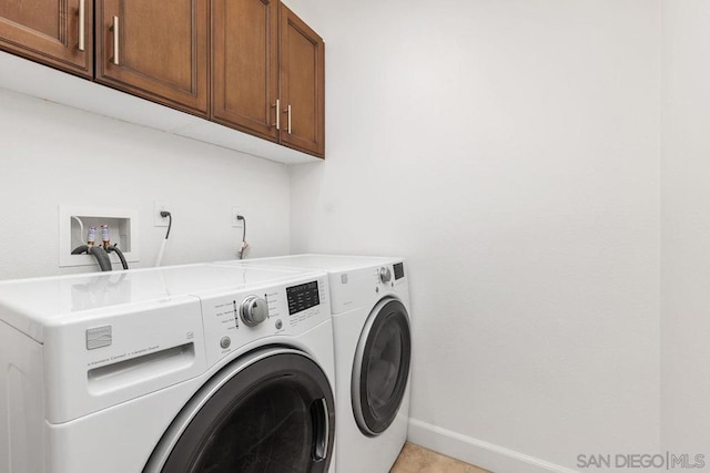 washroom featuring washing machine and dryer and cabinets