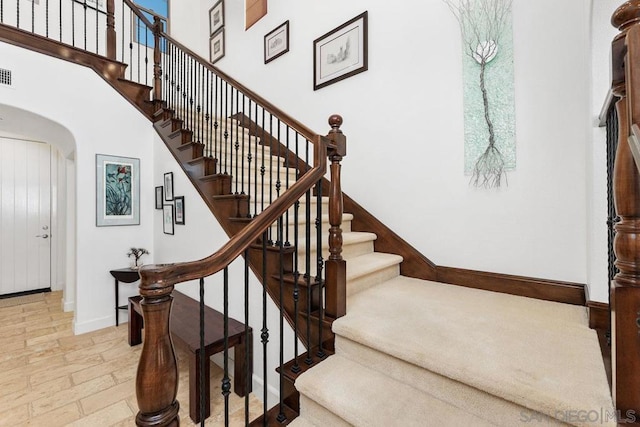 staircase featuring a towering ceiling