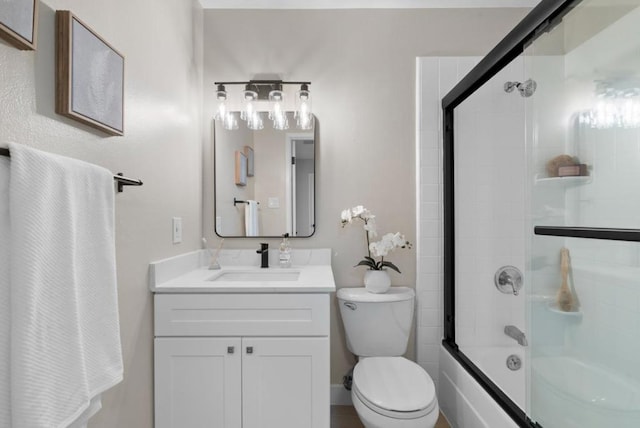 full bathroom featuring vanity, bath / shower combo with glass door, and toilet