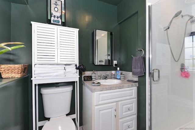 bathroom with vanity, a shower with shower door, and toilet