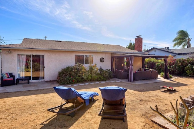 rear view of property featuring a patio and outdoor lounge area