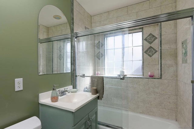 full bathroom with toilet, vanity, and shower / bath combination with glass door