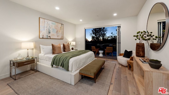 bedroom featuring access to exterior and light wood-type flooring