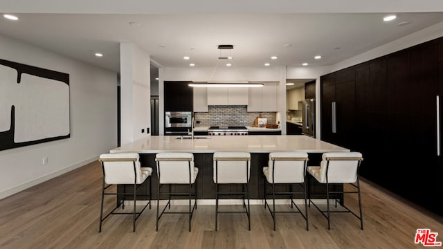 kitchen featuring a large island, tasteful backsplash, and a breakfast bar