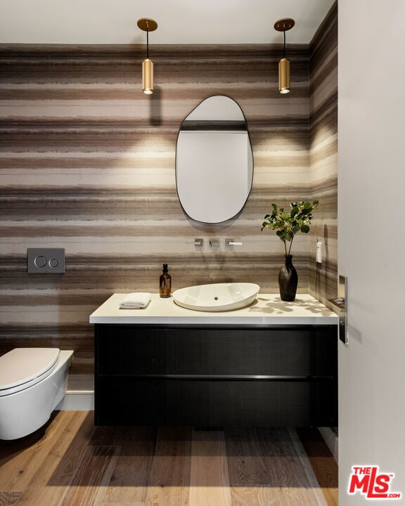 bathroom featuring vanity, wood-type flooring, and toilet