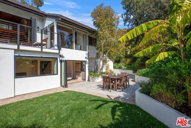 view of yard with a patio and a balcony