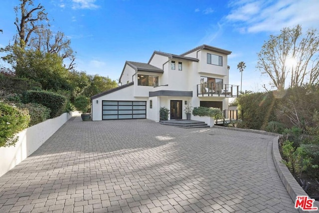 view of front of house featuring a garage and a balcony