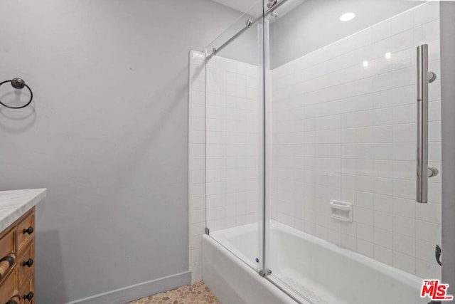 bathroom featuring vanity and shower / bath combination with glass door