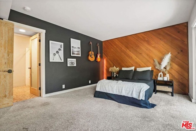 bedroom with carpet floors and wood walls