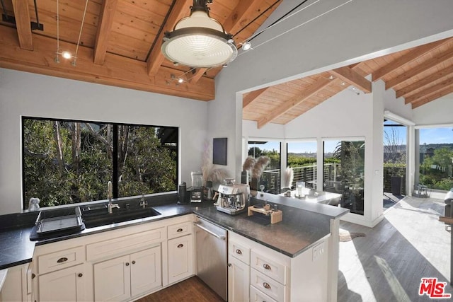 kitchen with beamed ceiling, stainless steel dishwasher, kitchen peninsula, and wooden ceiling