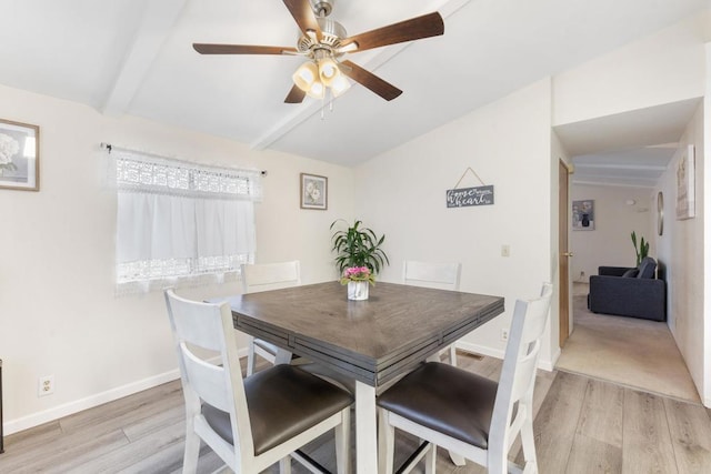 dining space with ceiling fan, beam ceiling, and light hardwood / wood-style floors