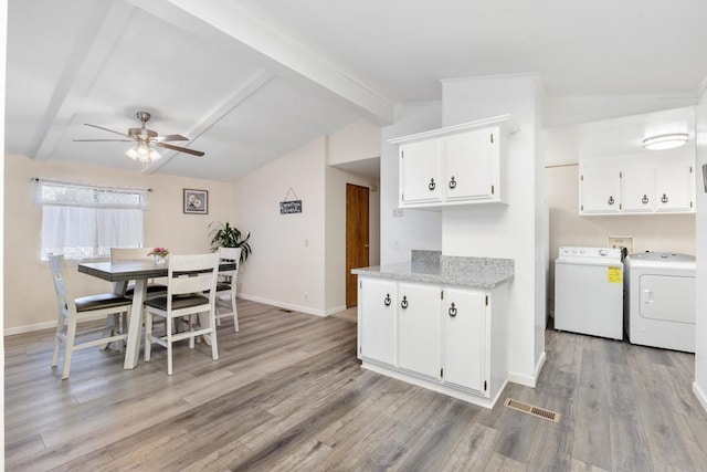 kitchen featuring separate washer and dryer, vaulted ceiling with beams, white cabinetry, and ceiling fan