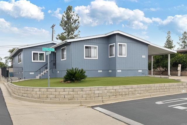 view of front of property with a front lawn and a carport