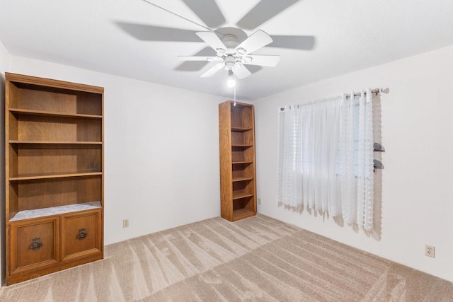 interior space featuring light colored carpet and ceiling fan