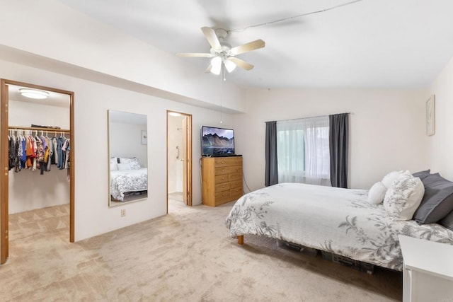 carpeted bedroom with ceiling fan, lofted ceiling, a spacious closet, and a closet