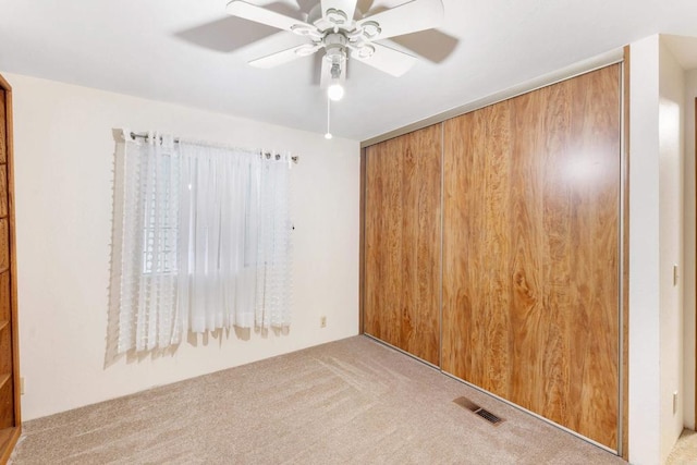 empty room with ceiling fan and light colored carpet