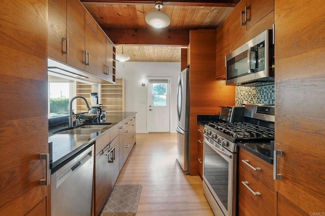 kitchen featuring beamed ceiling, stainless steel appliances, sink, and tasteful backsplash