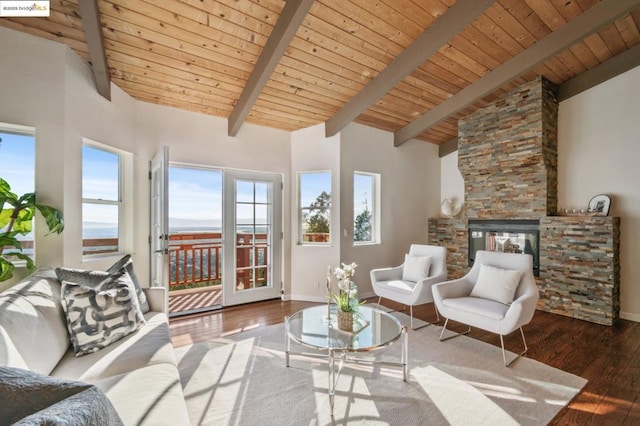 interior space with hardwood / wood-style flooring, a stone fireplace, high vaulted ceiling, and beam ceiling