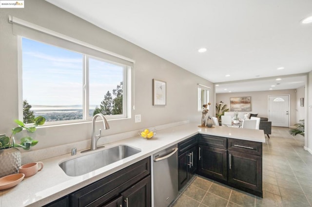 kitchen with stainless steel dishwasher, kitchen peninsula, and sink