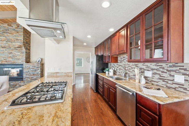 kitchen with appliances with stainless steel finishes, sink, backsplash, dark hardwood / wood-style flooring, and light stone countertops