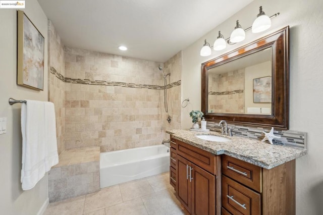 bathroom featuring vanity, tiled shower / bath combo, and tile patterned flooring