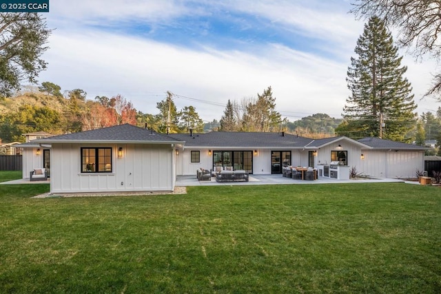 rear view of property featuring an outdoor living space, a patio, and a yard