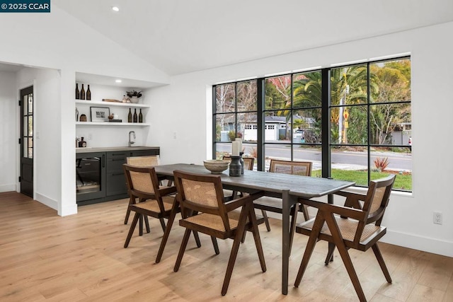 dining room with sink, beverage cooler, light wood-type flooring, and a wealth of natural light