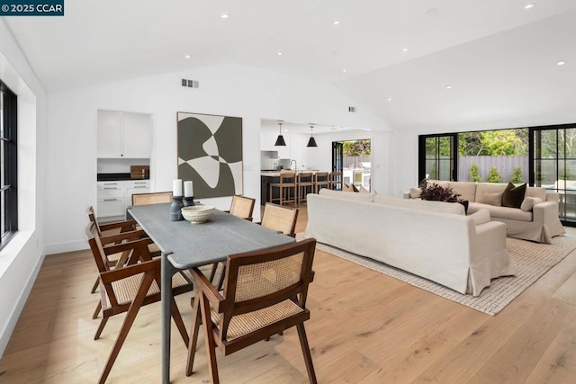 dining room featuring lofted ceiling and light wood-type flooring