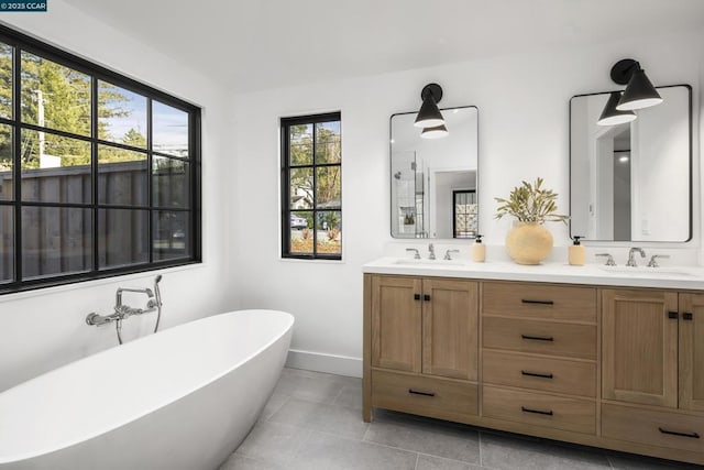 bathroom with tile patterned floors, vanity, and a washtub