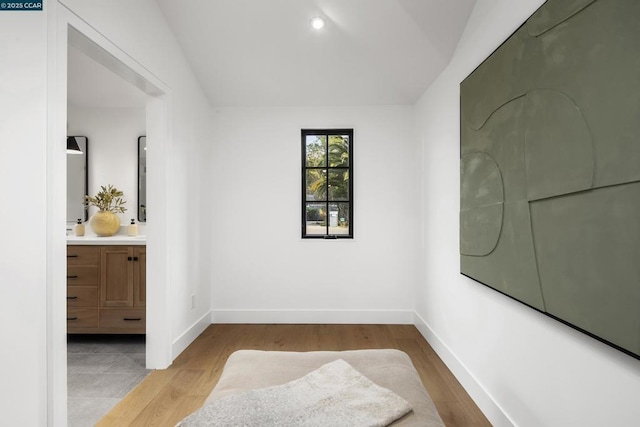 empty room with vaulted ceiling and light wood-type flooring