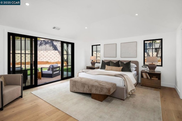 bedroom featuring access to outside, multiple windows, and light wood-type flooring