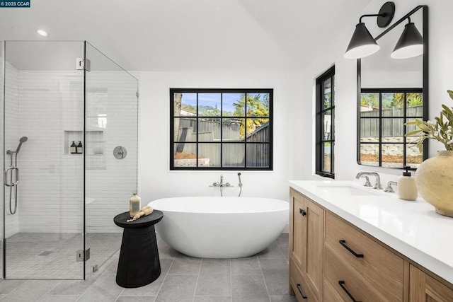 bathroom with independent shower and bath, vanity, and tile patterned flooring