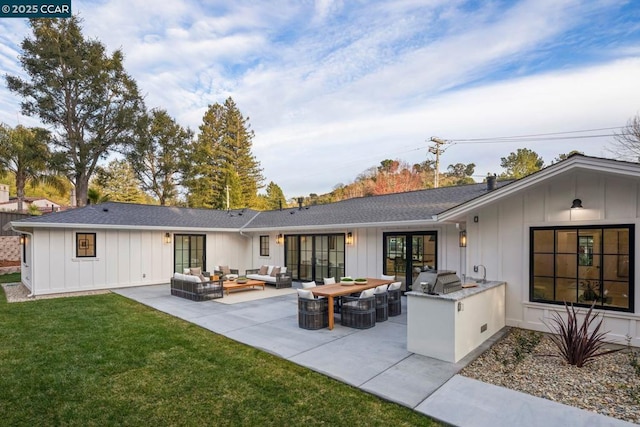 rear view of house featuring a yard, a patio area, an outdoor hangout area, and exterior kitchen