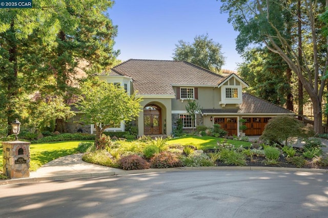 view of front of house featuring a garage, a front yard, and french doors