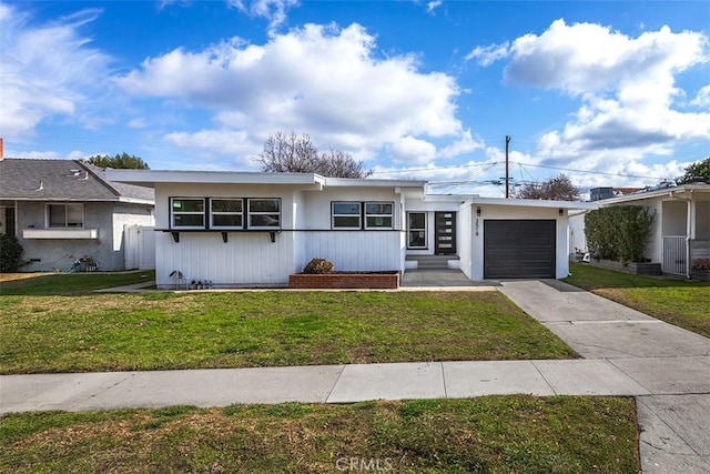 ranch-style house featuring a garage and a front lawn