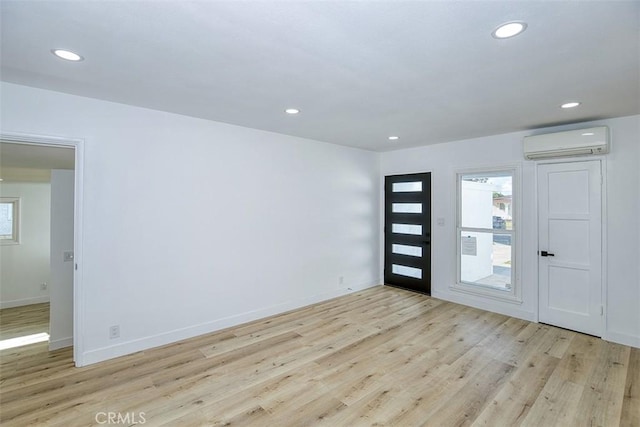 entryway featuring a wealth of natural light, a wall mounted AC, and light wood-type flooring