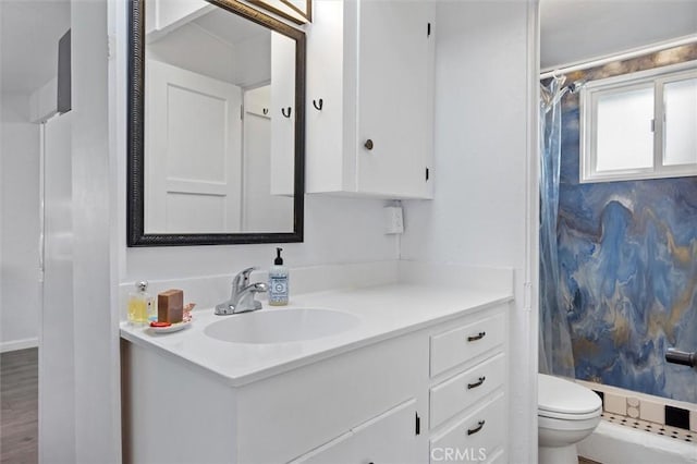 bathroom featuring vanity, a shower, and toilet