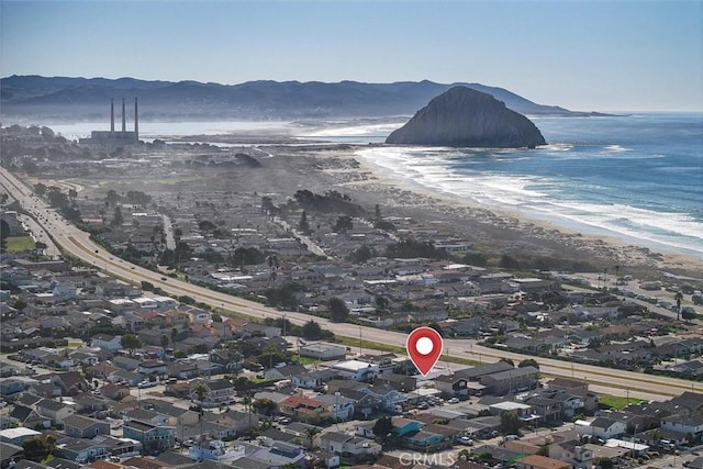 birds eye view of property with a water and mountain view and a beach view