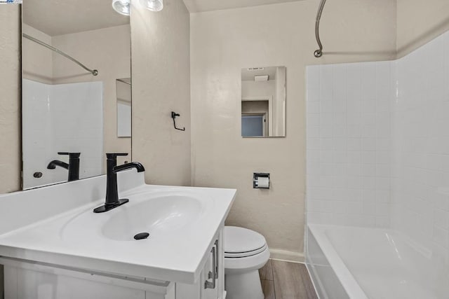 full bathroom featuring vanity, hardwood / wood-style flooring, toilet, and washtub / shower combination