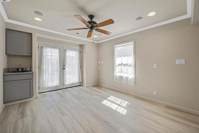 interior space featuring french doors, ornamental molding, plenty of natural light, and light wood-type flooring