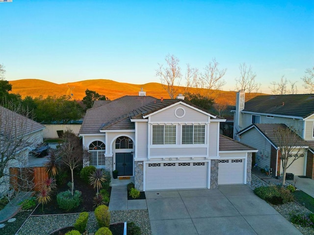 view of front of property with a garage and a mountain view