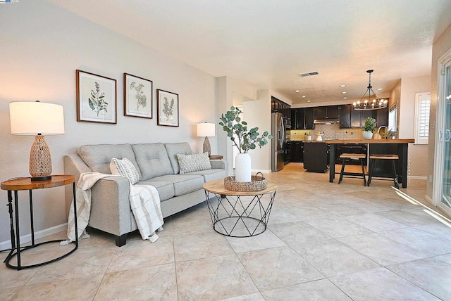 living room featuring sink and a notable chandelier