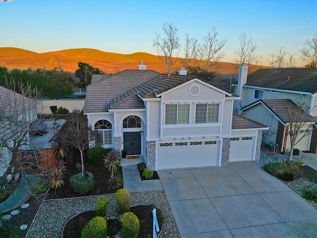 view of front facade with a mountain view and a garage