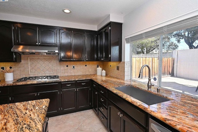 kitchen featuring tasteful backsplash, sink, stainless steel gas cooktop, and light stone counters