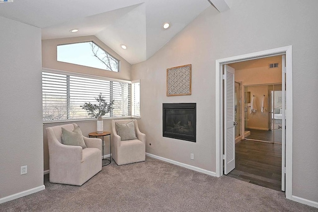 sitting room with high vaulted ceiling and carpet flooring