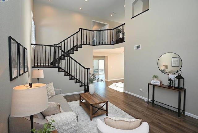 living room featuring a high ceiling, dark wood-type flooring, and a wealth of natural light