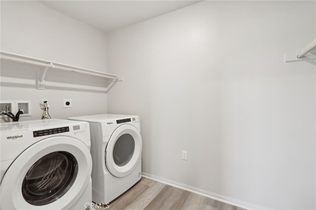 washroom featuring independent washer and dryer and light hardwood / wood-style floors