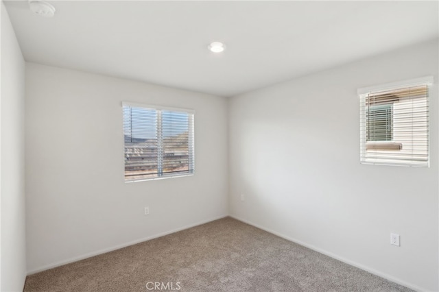 empty room featuring a healthy amount of sunlight and carpet flooring