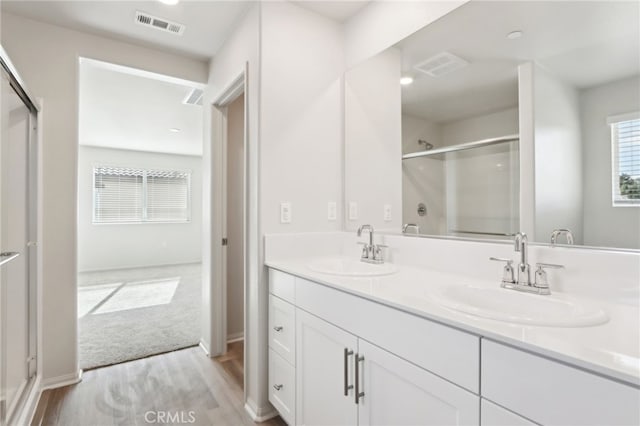 bathroom with vanity, hardwood / wood-style floors, and a shower with shower door