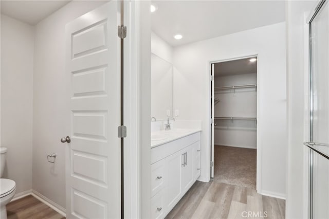 bathroom with wood-type flooring, toilet, and vanity